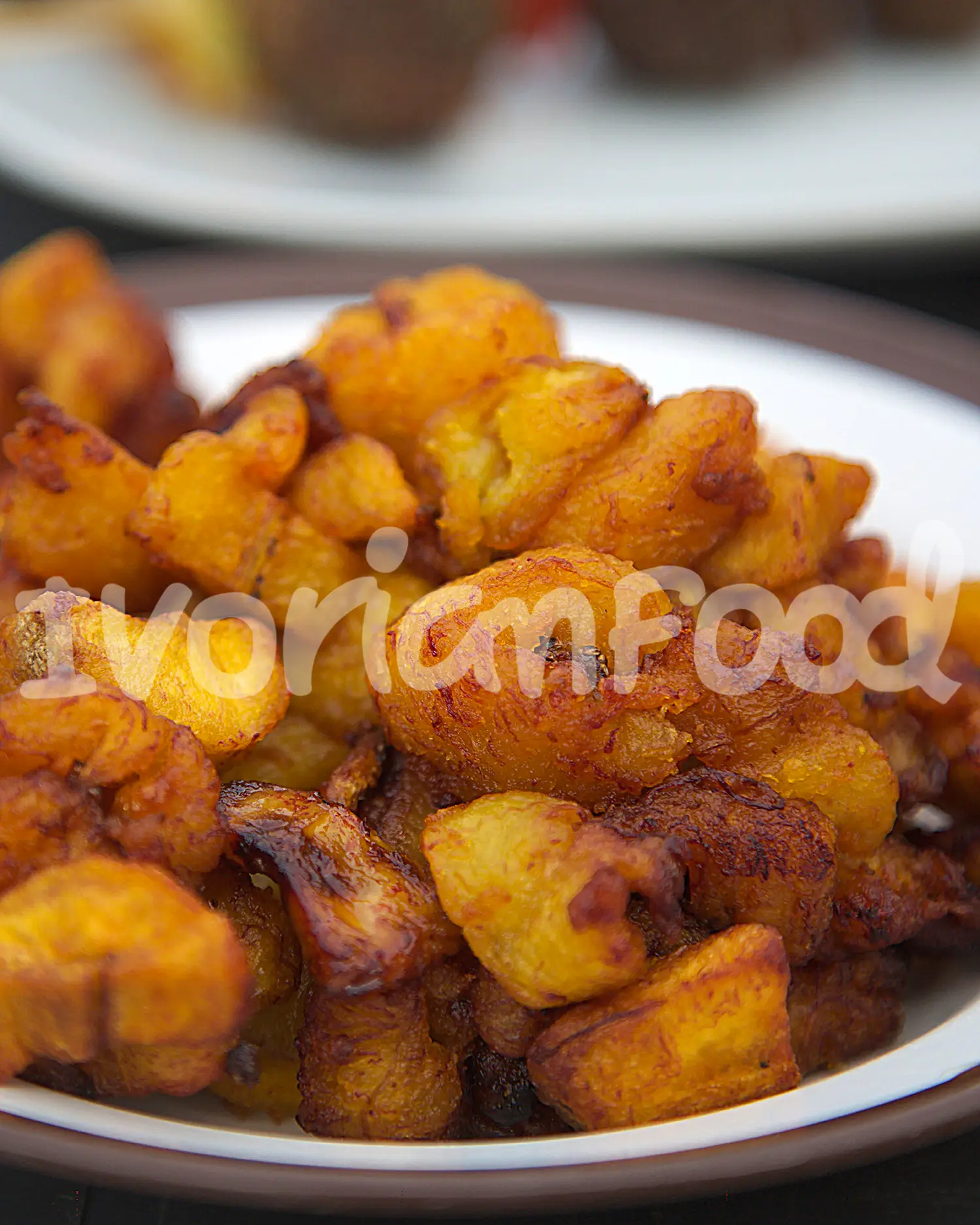 Alloco ivoirien : bananes plantains mûres frites jusqu’à croustillantes, saupoudrées de sel. Servir chaud avec sauce tomate épicée, poisson ou viande grillée.